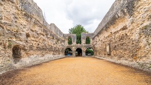 An ancient stone structure with arched doorways and a central open space. - Stylish Central 1-Bed Flat with Private Balcony | Pass the Keys (Reading)