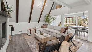 A spacious living room with a large sectional sofa, a coffee table, and a fireplace.