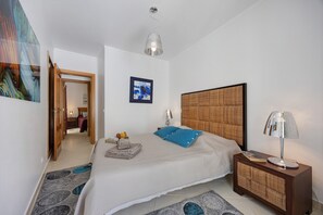 A bedroom with a bed, bedside table, lamp, and artwork on the wall. - Family Apartment in the Historic Center (Lagos)