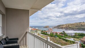 A balcony with a view of the sea and coastal buildings. - Vacation Home 'Santa Divina Relax Para 10 Personas' with Balcony and Wi-Fi (Asturias)