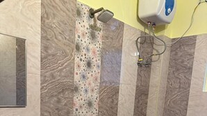A bathroom with a sink, toilet, shower, and a hand dryer. - Five stones By Earth Hotel Vadapalani (Chennai)