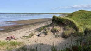 A beach with a picnic table and a fence along the shore. - Au Ptit Kakawi  (Miquelon-Langlade)
