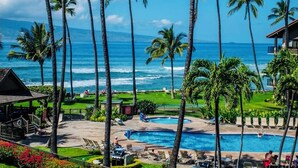 Un resort con piscina, palmeras y vista al océano.