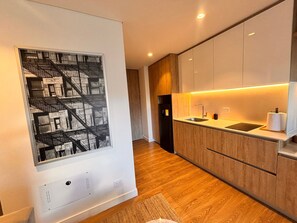 A modern kitchen with wooden cabinets, a built-in sink, and a black refrigerator.