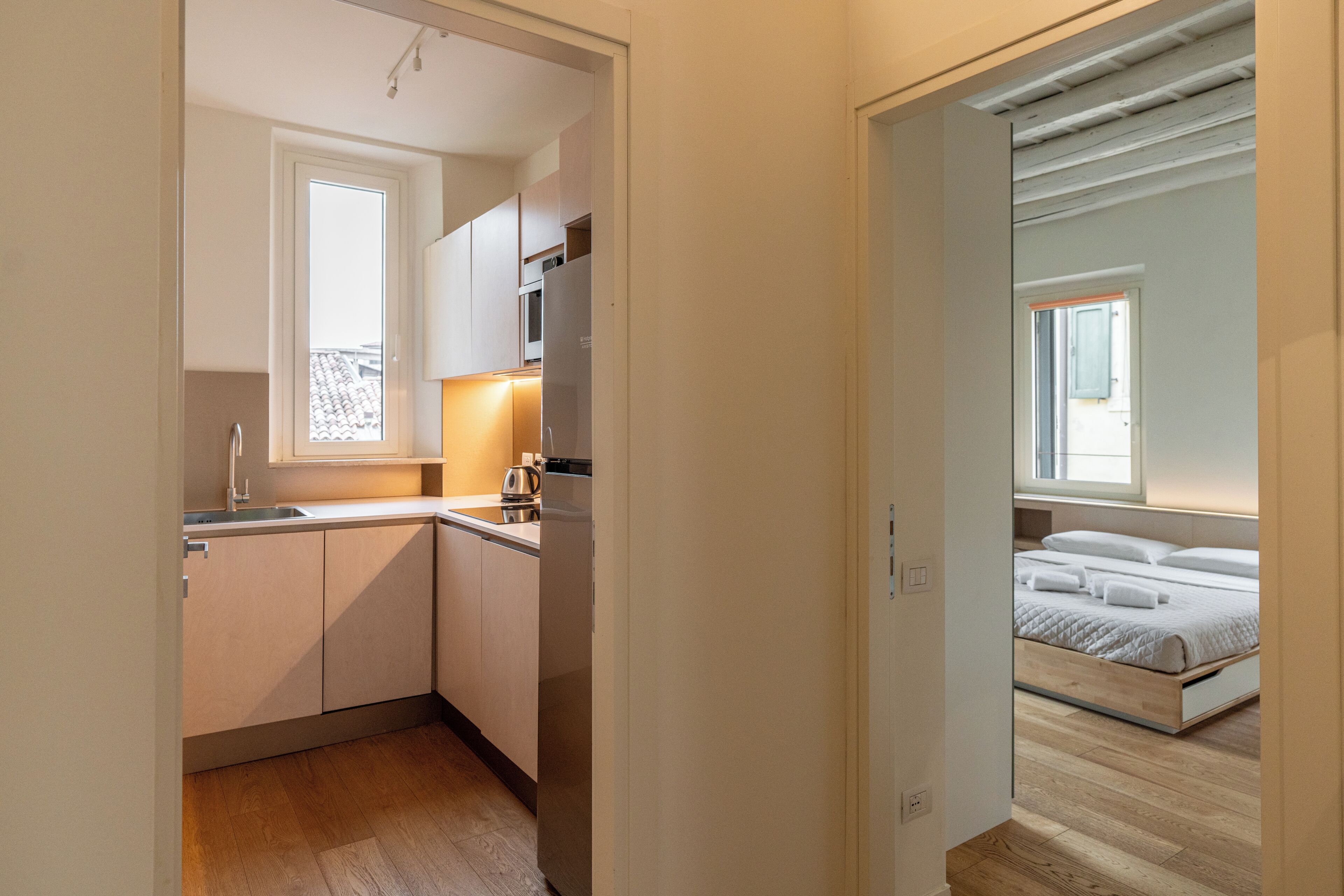 A compact kitchen with a window, a built-in oven, and a dishwasher.