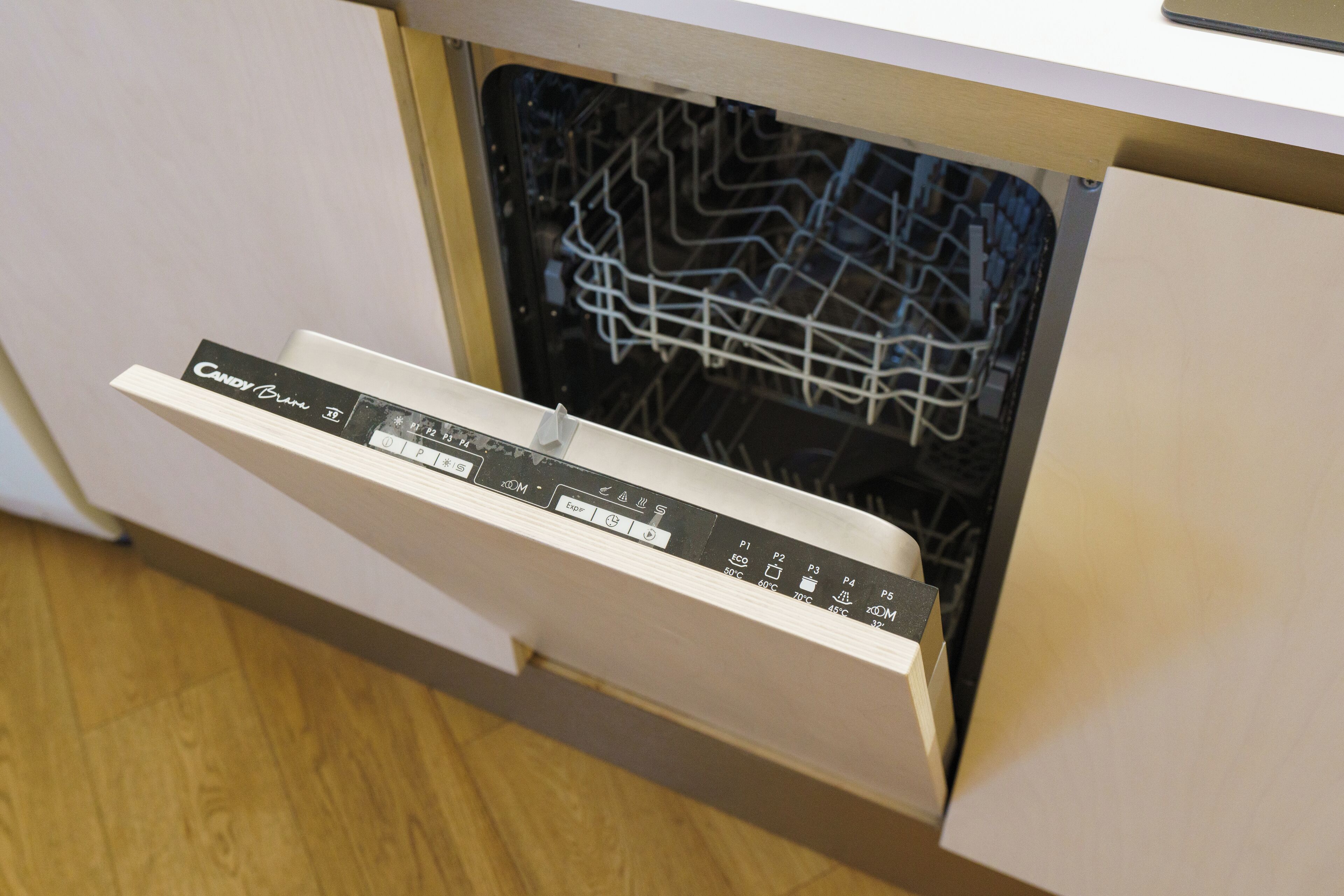 A dishwasher with a control panel and a rack inside.
