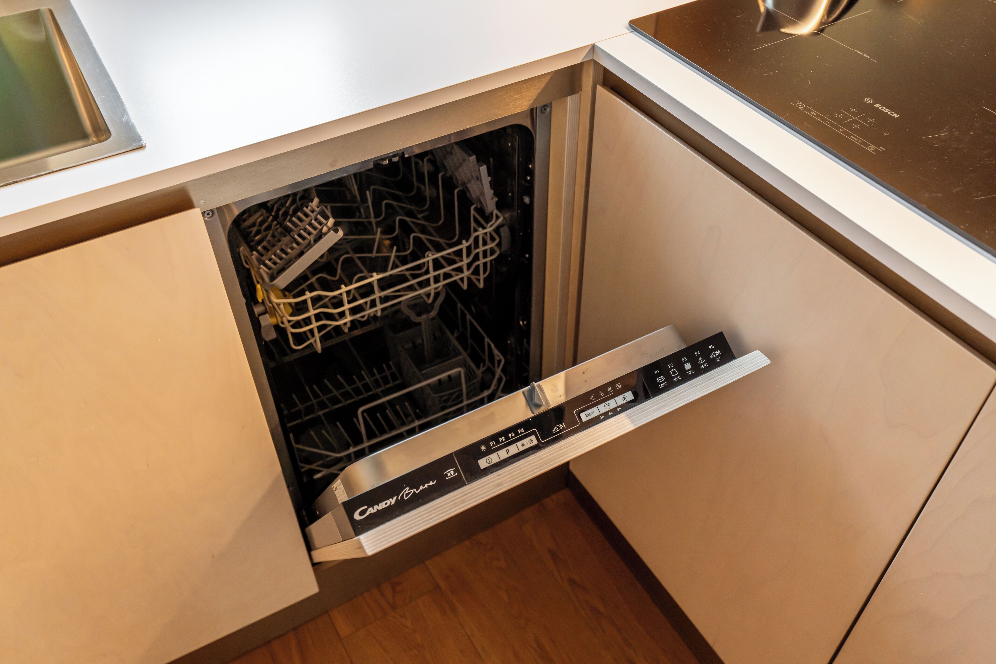 A Bosch dishwasher with a control panel and a rack inside.