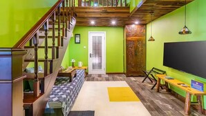 A multi-level interior with a staircase, a large flat-screen TV, and a bench. - Beijing Shixi Inn near Forbidding City (Beijing)