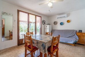 A dining area with a table, chairs, and a ceiling fan. - House for 6 people, ground floor, beach, pool (Vendres)