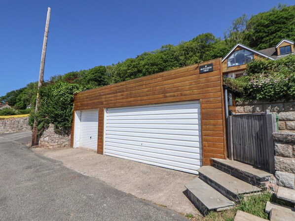 A two-car garage with a wooden facade and a sign reading "Buzzards View".