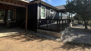 Une maison à deux étages dotée d’un porche abrité et d’une cour clôturée.