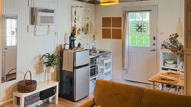 A compact living space with a kitchenette, a sofa, and a dining area.