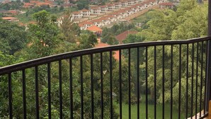 Zona residencial amb diversos edificis, un parc verd i vista a les colines llunyanes.