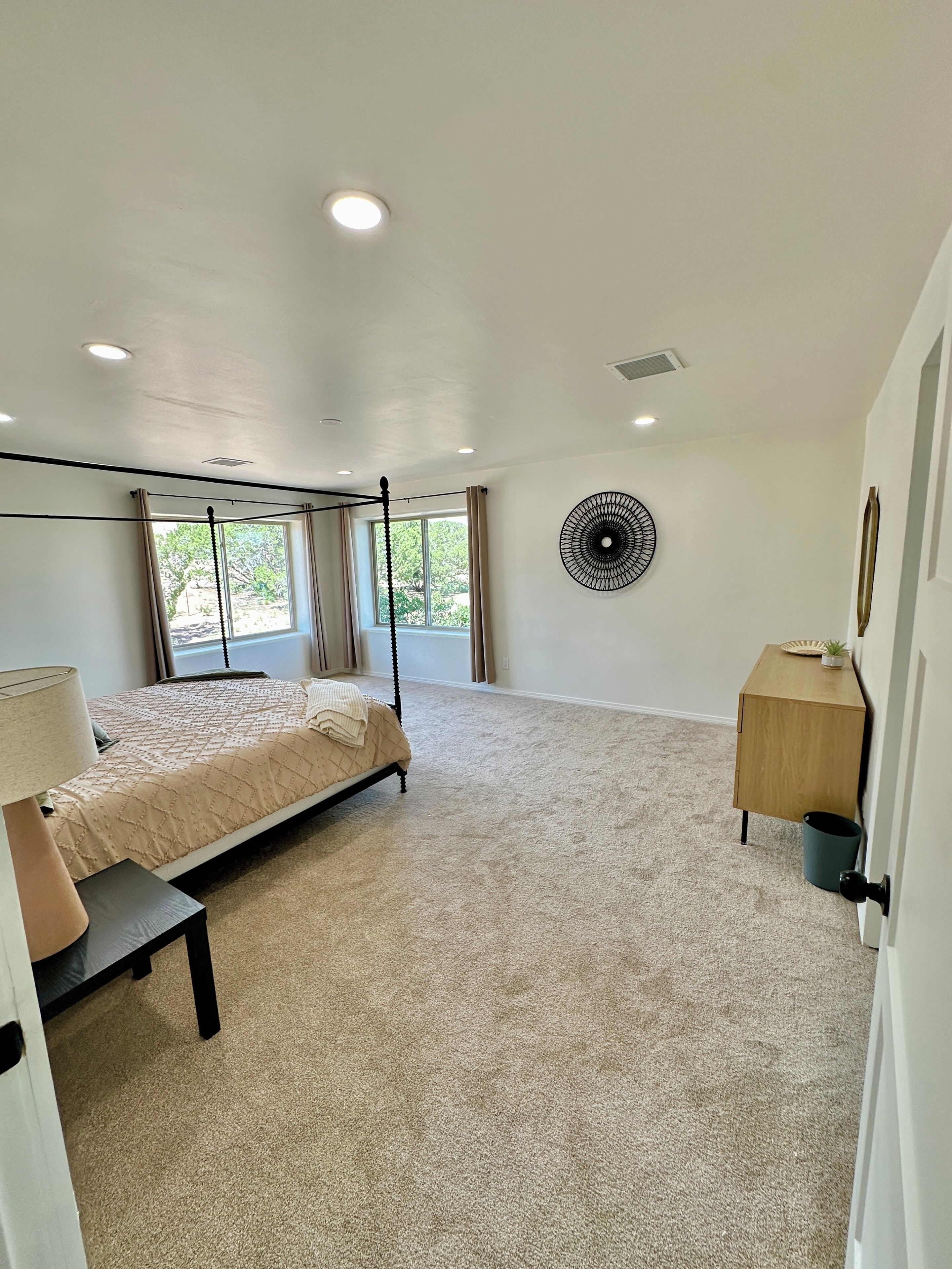 A bedroom with a bed, bedside table, and a wall-mounted circular decorative item.