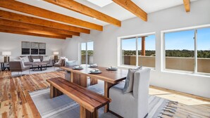 Un'ampia zona giorno con soffitto in legno, un tavolo da pranzo grande e un divano.