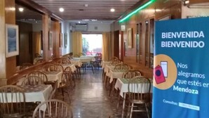 Ein Restaurantinnenraum mit Tischen und Stühlen, einem blauen Willkommensbanner und Holzwandverkleidung.