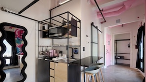 A compact kitchen with a central island, built-in appliances, and a unique black-framed mirror. - BIG LITTLE HOTEL  (Denver)