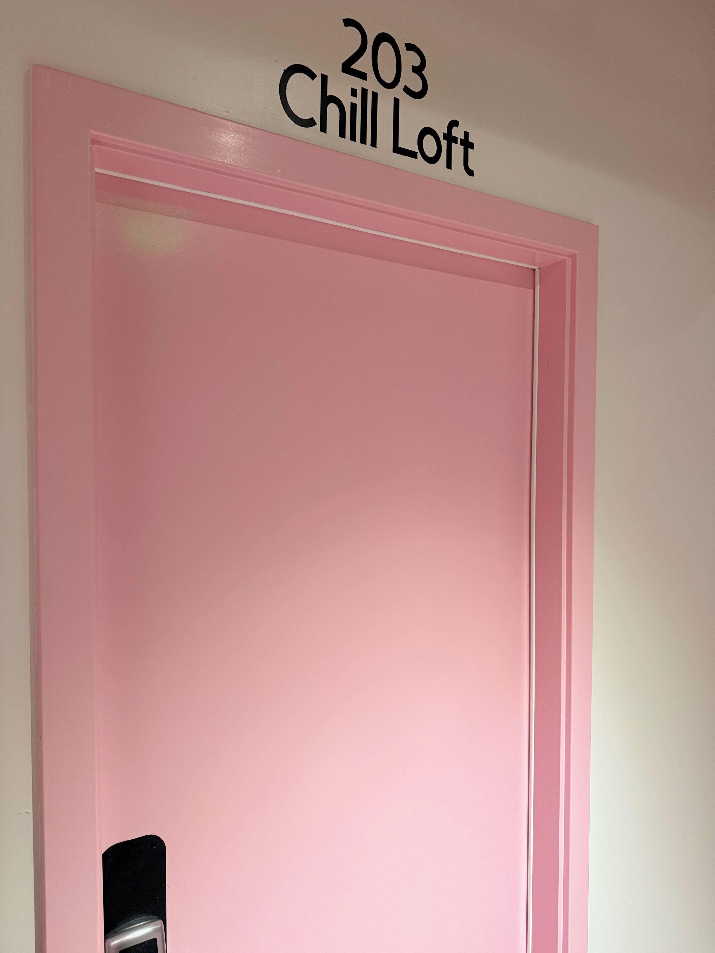 A pink door with the number '203' and the words 'Chill Loft' above it.
