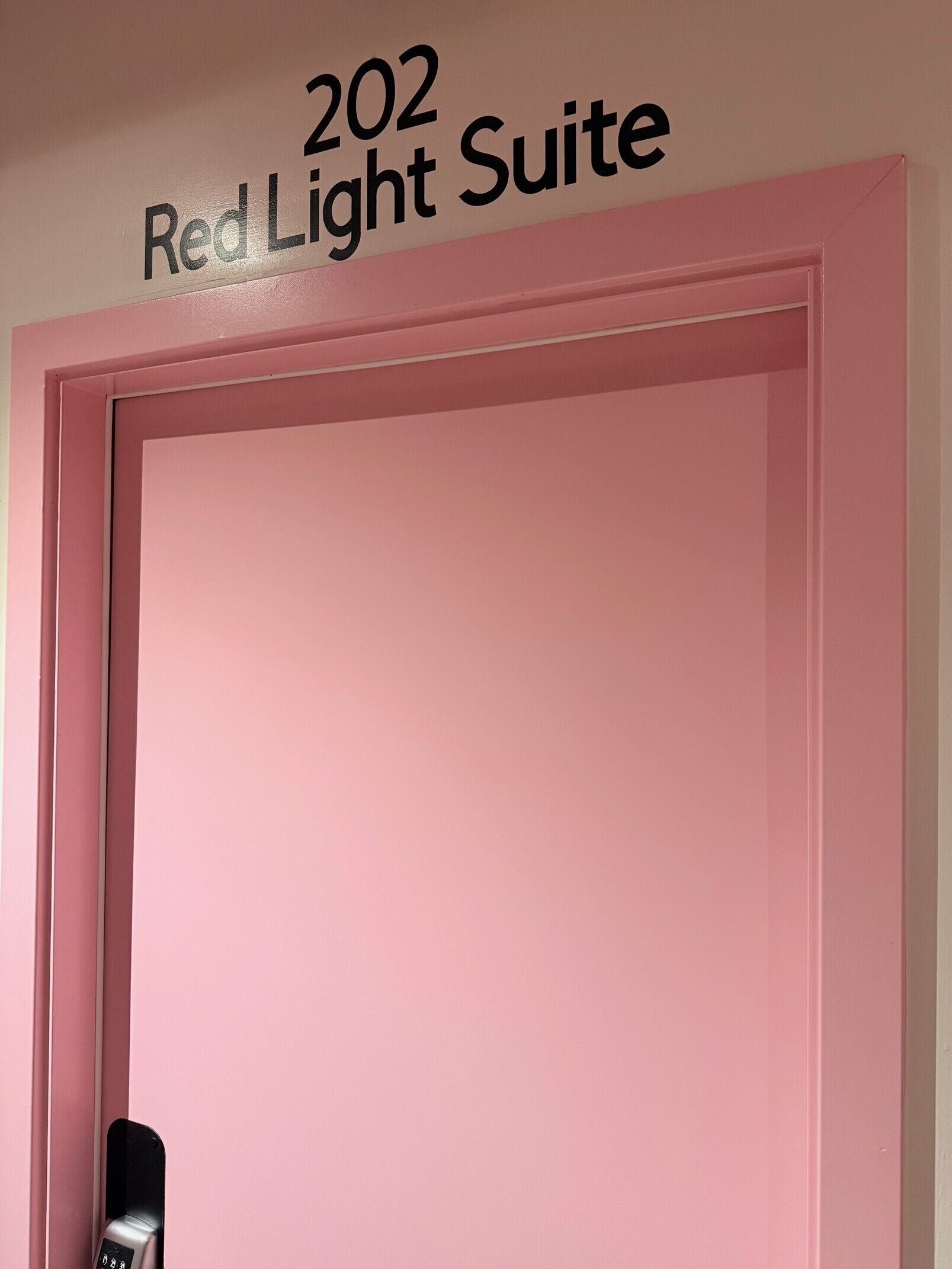 Eine Tür mit einem Schild darüber, auf dem '202 Red Light Suite' steht.