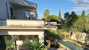 A modern house with a pool, outdoor furniture, and lush greenery. - CASA LUMA between the sea and Montpellier (Lattes)