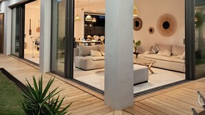 A modern house with a spacious patio, large windows, and a well-lit interior. - CASA LUMA between the sea and Montpellier (Lattes)