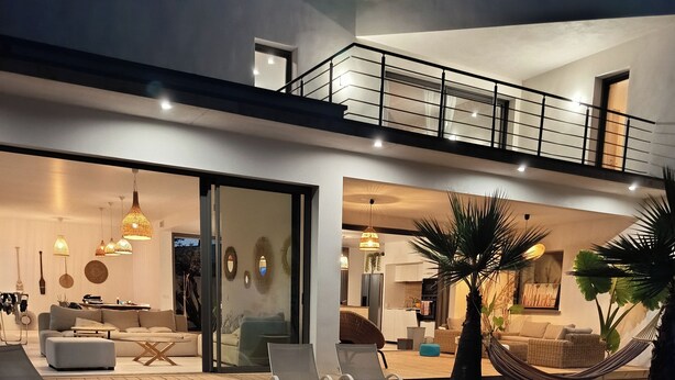 A modern house with a swimming pool, outdoor seating, and a well-lit interior. - CASA LUMA between the sea and Montpellier (Lattes)