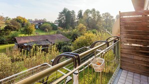 A balcony with a metal railing, a wooden fence, and a view of a garden and a house in the background. - Cadrezzate With Osmate (VA) (Osmate)