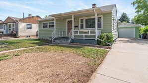 A single-story house with a front porch, a garage, and a small front yard. - ⁂Pet-friendly⁂Fenced yard w/deck⁂Pool Table⁂ (Rapid City)