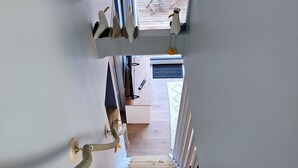 A wooden staircase leading to a room with a view of the outside.
