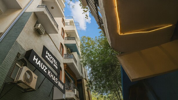 A hotel named "HAUZ KHAS" with a signboard, air conditioning units, and a balcony. - Hotel Hauz Khas Inn (New Delhi)
