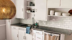 A kitchen with white cabinets, a stainless steel dishwasher, and a hanging pendant light. - Digs 3 of 5: 2BDRM, Open & Airy, Private Parking, Central, 2nd Floor & More! (Evansville)
