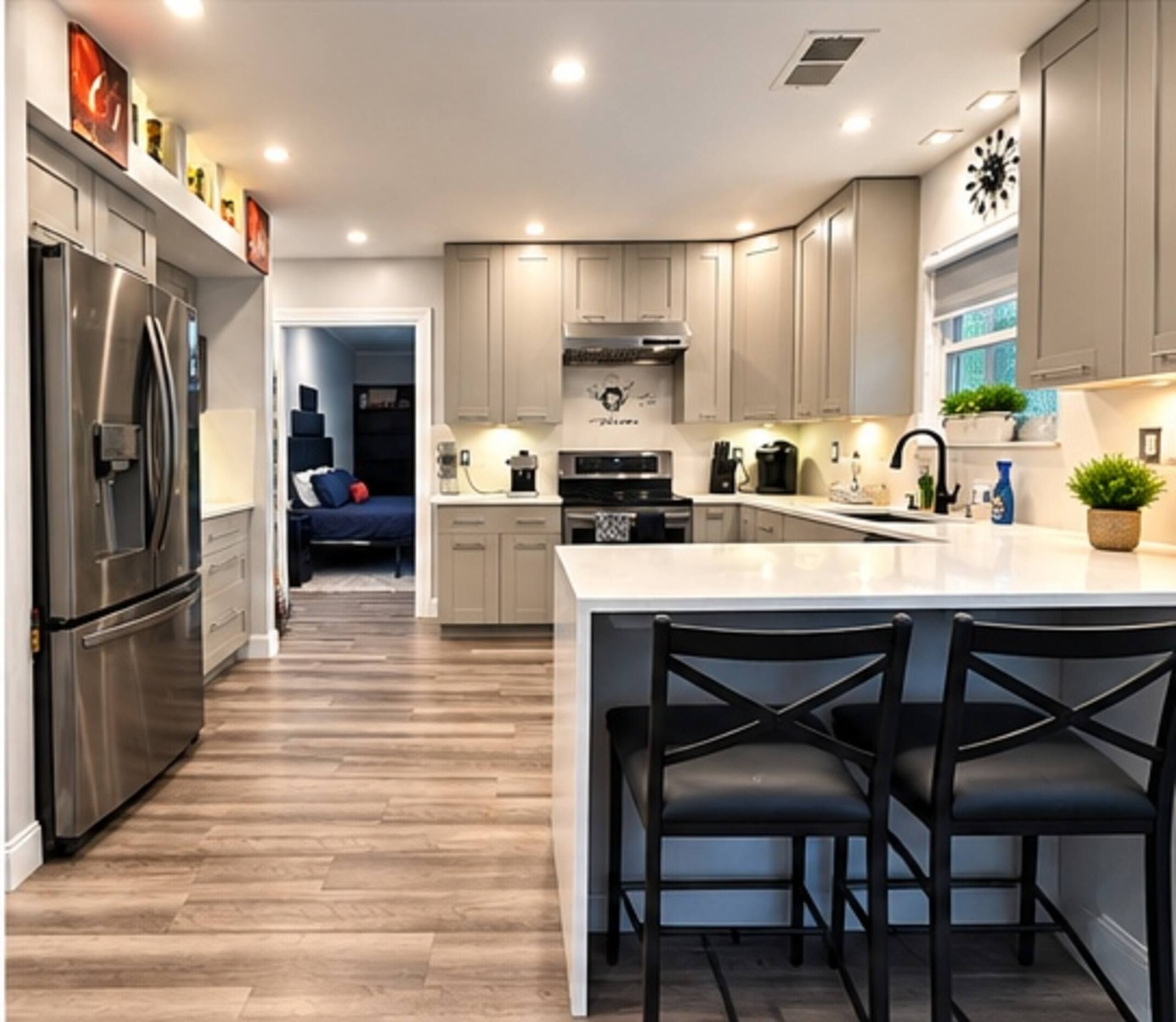 A modern kitchen with a central island, stainless steel appliances, and a dining area with black chairs.