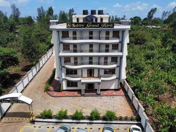 A multi-story hotel named "Sabby Grand Hotel" with a central entrance, balconies, and a parking area. - Sabby Grand Hotel (Thika)