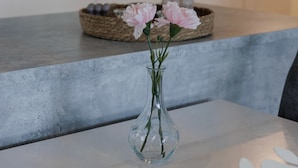 A clear view of a kitchen counter with a vase of flowers and a woven basket. - Spacious 2BR Apt - Lake View & Sauna (Jyväskylä)