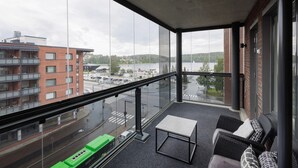 A balcony with a view of a lake, a table, and seating. - Spacious 2BR Apt - Lake View & Sauna (Jyväskylä)