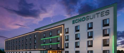 Un hotel con fachada moderna, varios ventanales y un letrero que dice 'ECHO SUITES'.