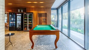 A pool table in a modern room with wooden ceiling and large windows. - High-standard Studio in Moinhos Gos1007 (Porto Alegre)