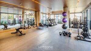 A spacious gym with various exercise equipment, large windows, and a modern design. - High-standard Studio in Moinhos Gos1007 (Porto Alegre)