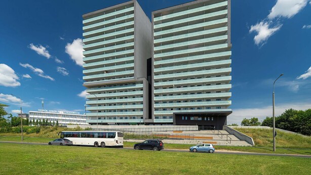 Ett modernt hotell med en tvåvåningsbyggnad, ett platt tak och en väl synlig skylt.