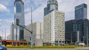 Un paisaje urbano con modernos edificios altos, un tranvía y un semáforo.