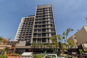 Een meerhoog gebouw met een modern architectonisch ontwerp, met balkons en een plat dak.