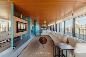 A modern interior with a long corridor, a large sofa area, and a TV mounted on the wall.