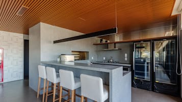 A modern kitchen with a central island, bar stools, and stainless steel appliances.