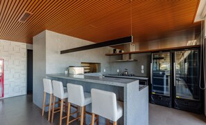 A modern kitchen with a central island, bar stools, and stainless steel appliances.