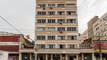 A multi-story building with a flat facade, multiple windows, and air conditioning units.
