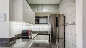 A modern kitchen with stainless steel appliances, a built-in microwave, and a coffee maker. - Practical Studio Near Farroupilha Park Hpn707 (Porto Alegre)