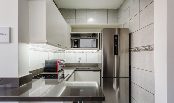 A modern kitchen with stainless steel appliances, a built-in microwave, and a coffee maker.