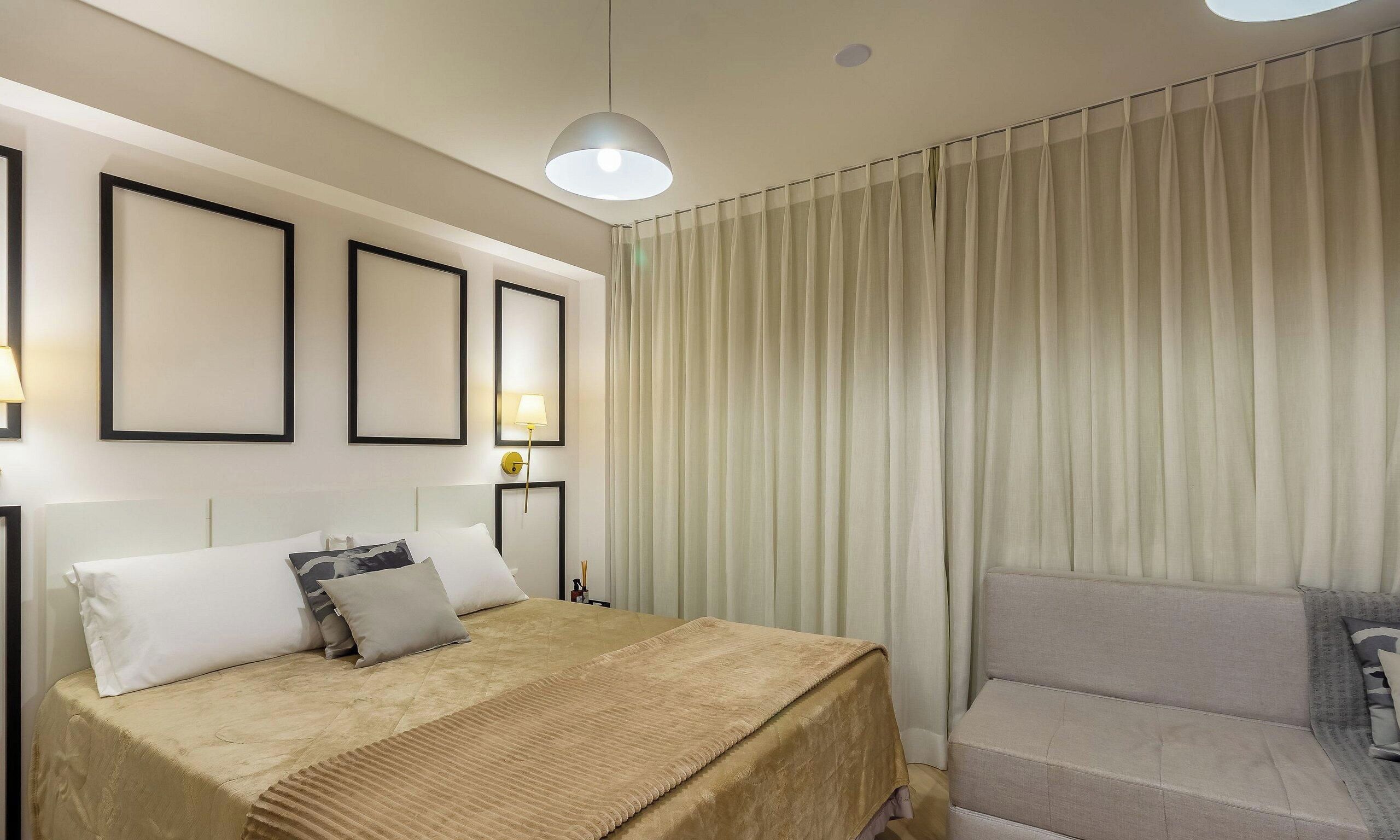 Una habitación de hotel con una cama, una silla, una lámpara y cortinas.