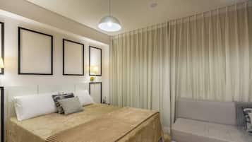 Una habitación de hotel con una cama, una silla, una lámpara y cortinas.