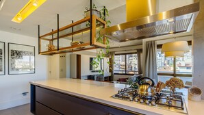 A modern kitchen with a central island, stainless steel appliances, and a city view through large windows. - Comfort and a Beautiful View! Pgr1101 (Porto Alegre)